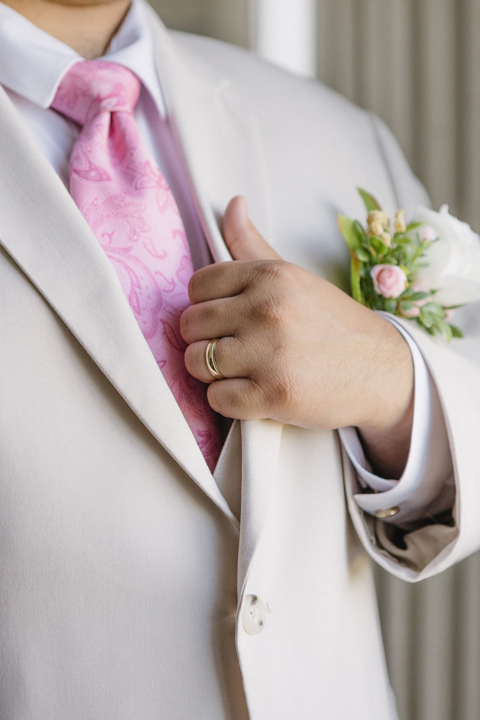 Wedding suit with a pink tie and boutonniere